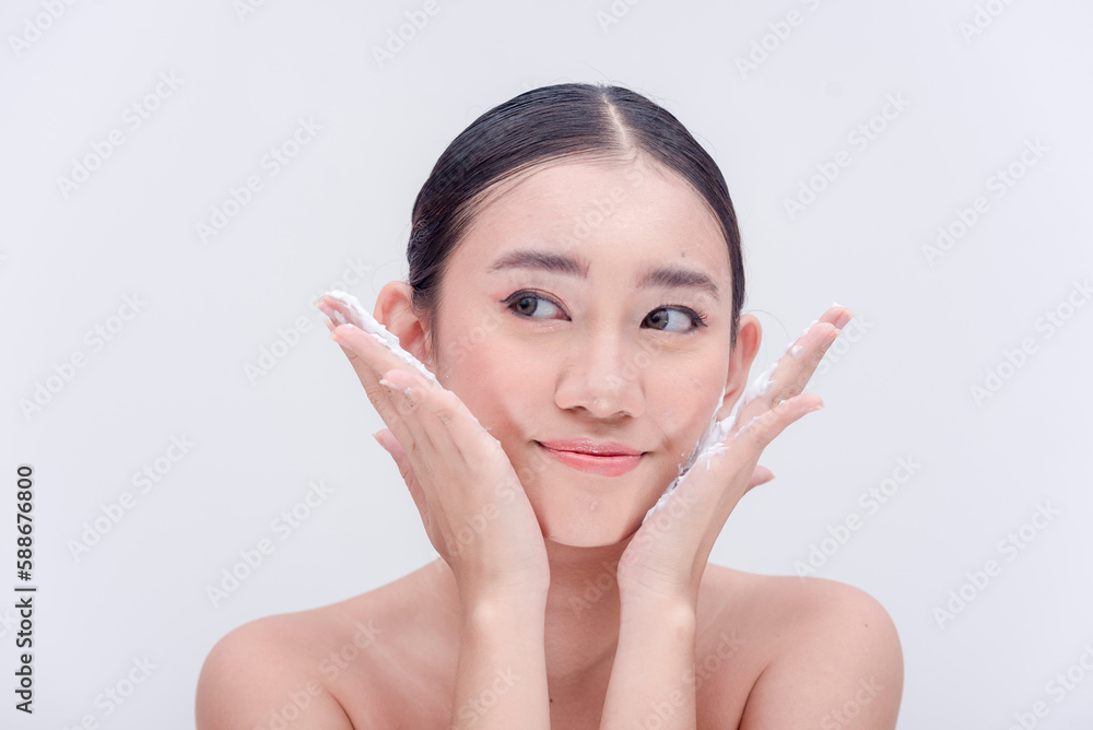 Studio picture of a beautiful millennial woman rinsing off the lather of soap on her face while looking sideways. Isolated on a white background. Studio picture of a beautiful millennial woman rinsing off the lather of soap on her face while looking sideways. Isolated on a white background.