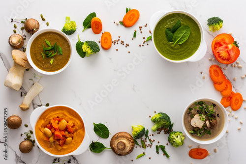 Mushroom and lentil cream soup, bean, carrot and tomato soup, broccoli and spinach soup on white background with cooking ingredients, copy space