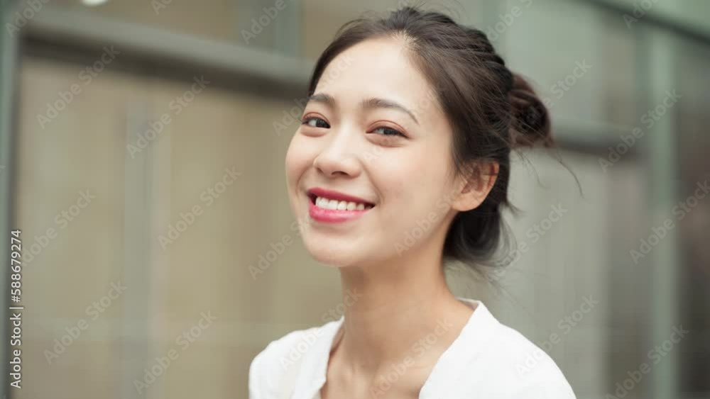 Young beautiful Asian Chinese girl looking at the camera and smiling sweetly Young beautiful Asian Chinese girl looking at the camera and smiling sweetly