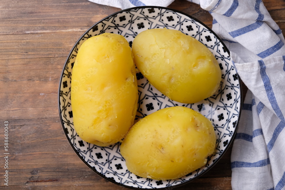 3 peeled boiled potatoes on a ceramic plate with an Asian pattern on gray marble table. carbohydrate. kentang rebus. 
