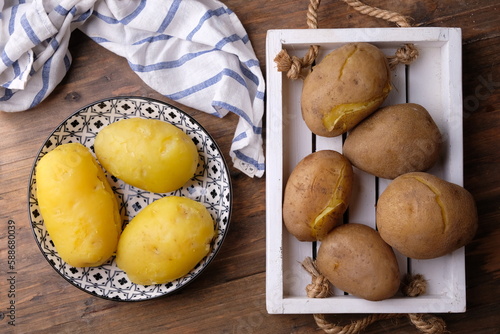 Tableau sur toile boiled potatoes on a wooden cutting board and peeled boiled potatoes on a ceramic plate with an Asian pattern