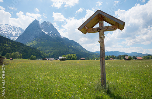 wayside cross at green pasture, view to Waxenstein mountains, landscape near Garmisch-Partenkirchen