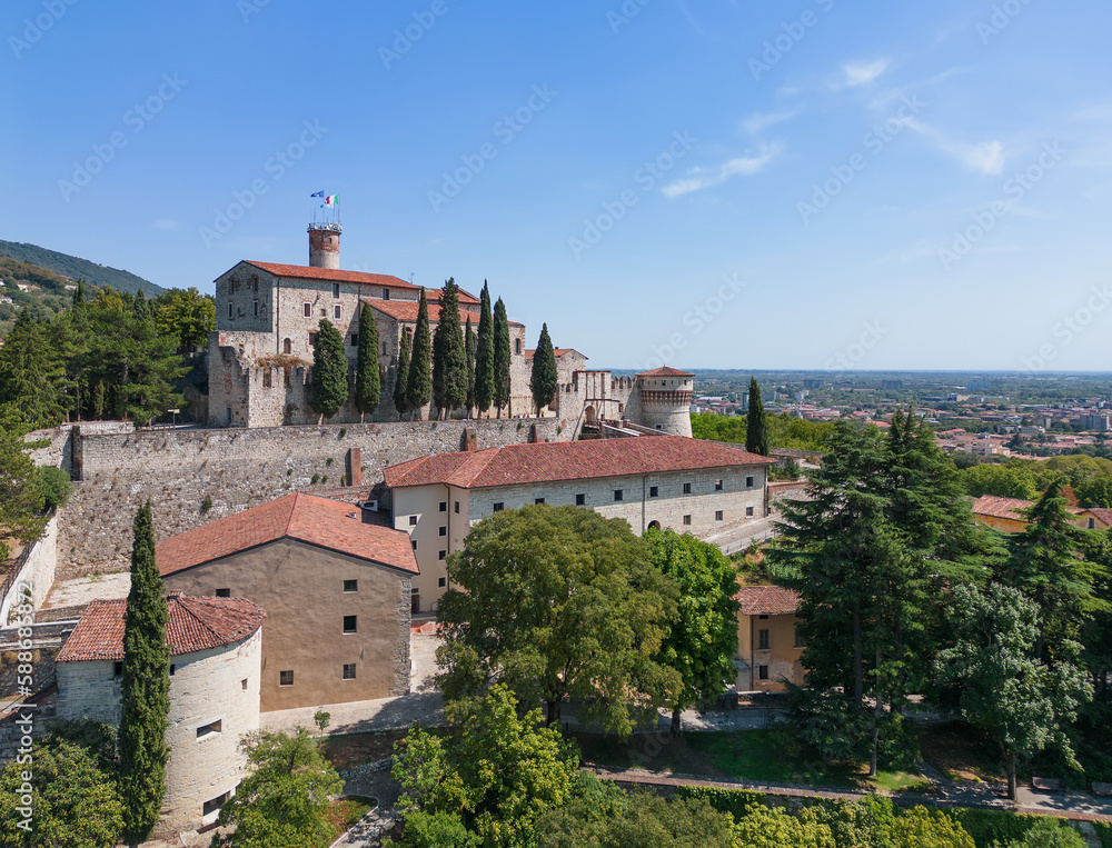 Panoramic drone view of the western part of the historical castle in the town of Brescia and the surrounding old park. Lombardy, Italy