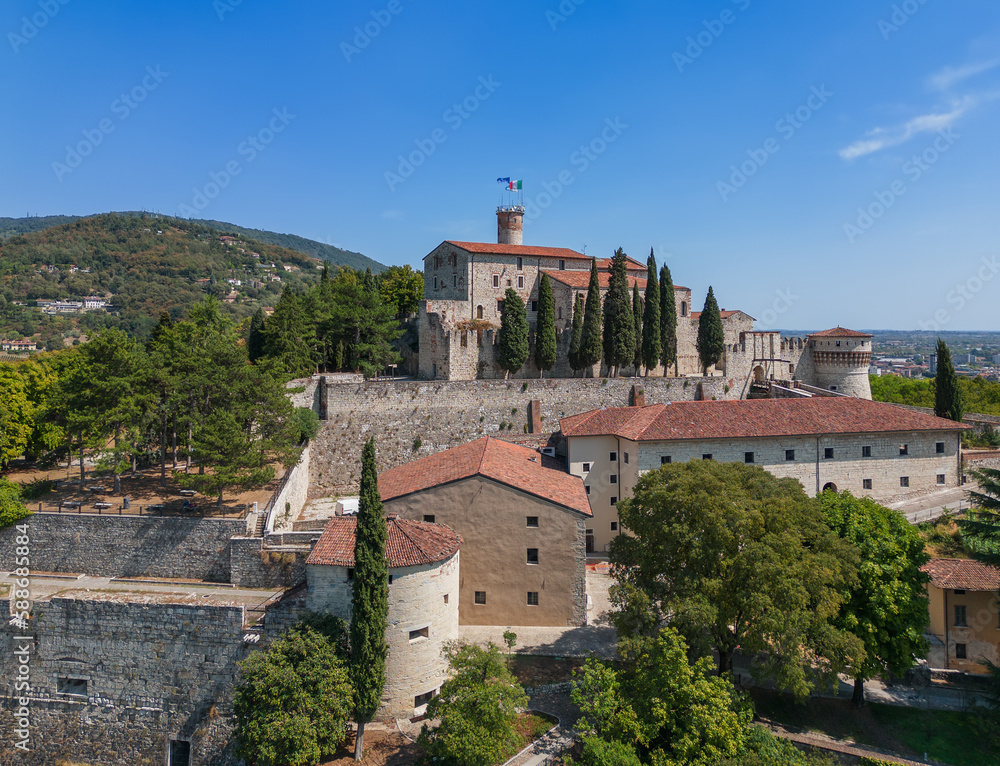 Obraz premium Panoramic drone view of the hill (colle Cidneo) with old castle and park in the center of Brescia city on a bright sunny day. Lombardy, Italy