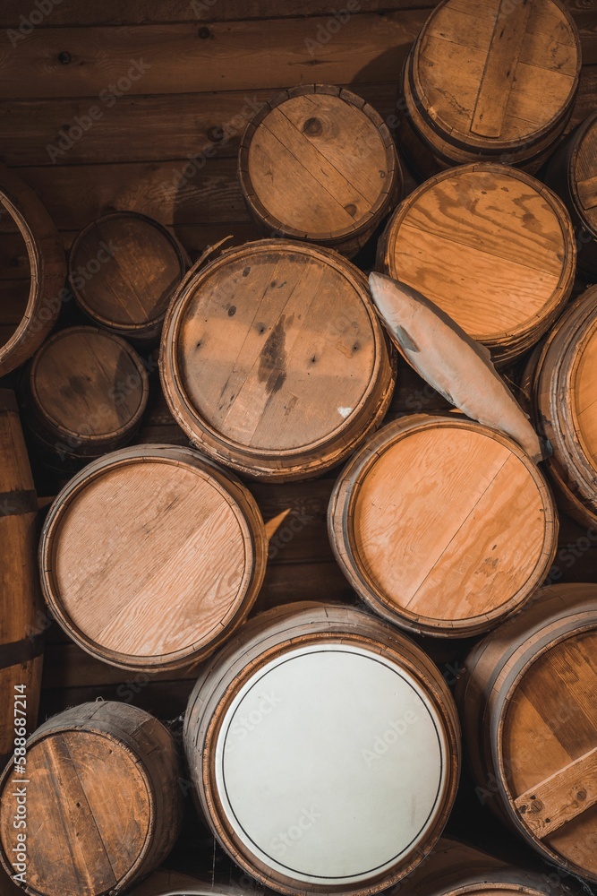 Vertical shot of stack of old wine barrels in the wooden basement Vertical shot of stack of old wine barrels in the wooden basement