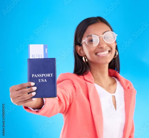Obraz Passport, ticket and portrait of woman in travel, flight or USA documents against a blue studio background. Happy female business traveler smile holding international boarding pass or booking trip