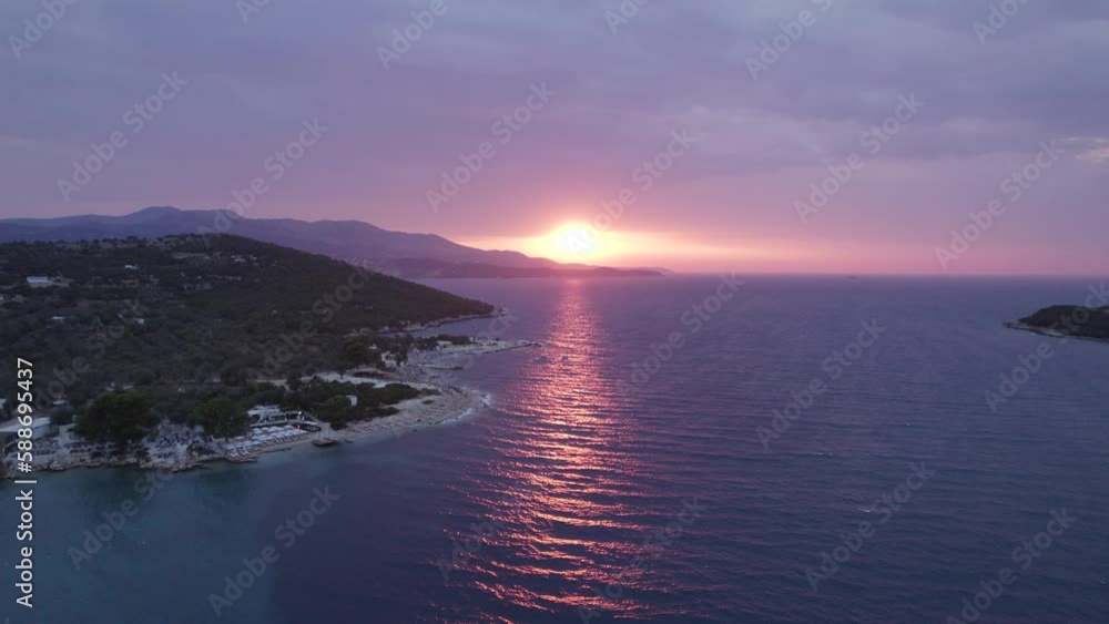 Calm purple-hued sunset shining on rippling ocean at Ksamil shore, Albania Calm purple-hued sunset shining on rippling ocean at Ksamil shore, Albania