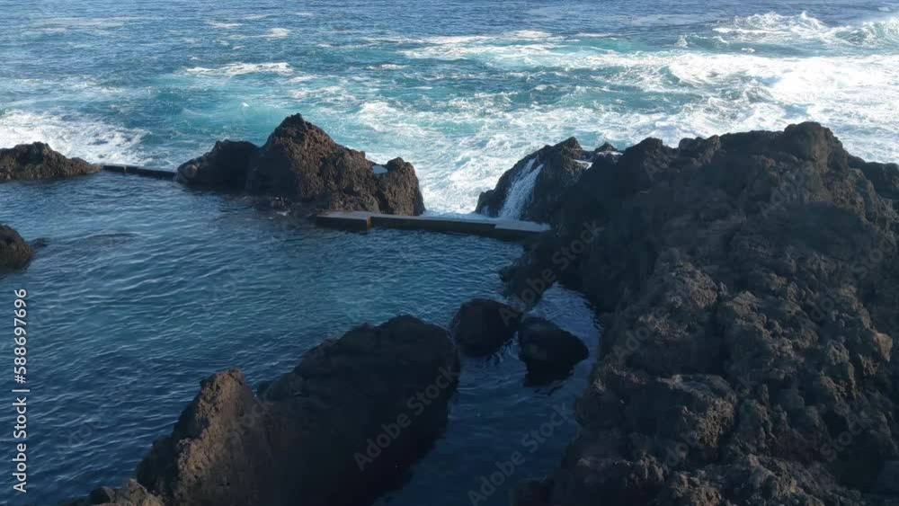 View of the volcanic coast of the island. The waves of the ocean wash the shore