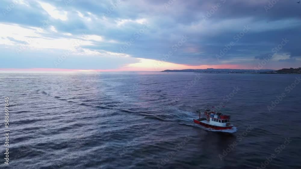 Aerial of a sailing boat on the blue tranquil seascape captured at sunset Aerial of a sailing boat on the blue tranquil seascape captured at sunset