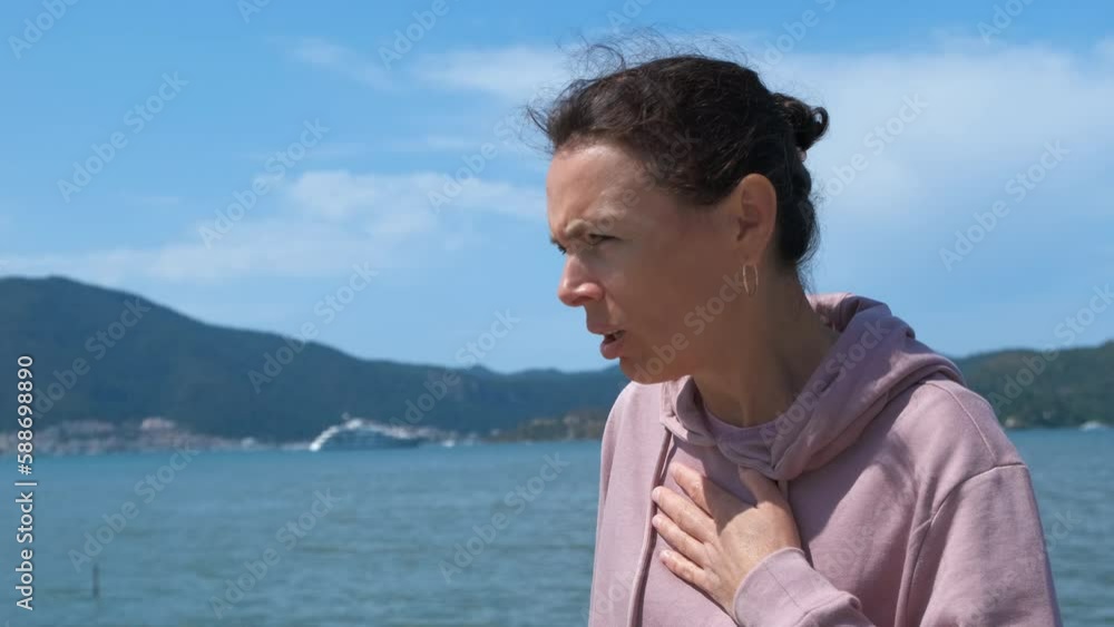 The woman gasps. The female chokes on asthma and uses an inhaler on the seashore. The woman gasps. The female chokes on asthma and uses an inhaler on the seashore.
