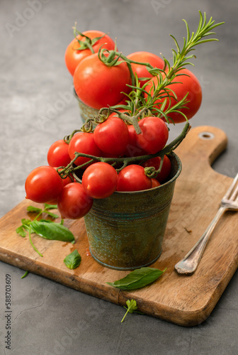Cherry tomatoes and tomatoes on vine with herbs