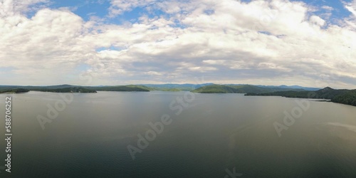 Wide angle drone view of Lake Jocassee surrounded by hills under a cloudy sky in South Carolina, USA