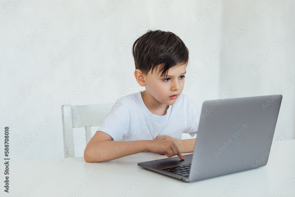 a boy sitting at a laptop at a desk in a classroom education online school a boy sitting at a laptop at a desk in a classroom education online school