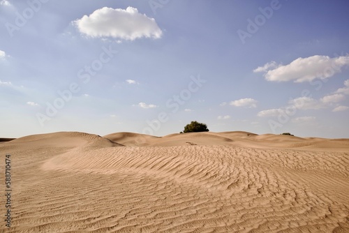 Scenic view of large desert landscape with sand dunes under blue cloudy sky