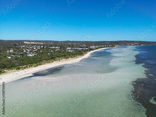 Aerial view of a shoreline of turquoise water under blue sky