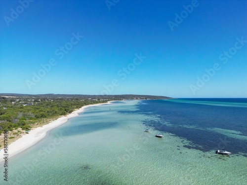 Aerial view of a shoreline of turquoise water under blue sky