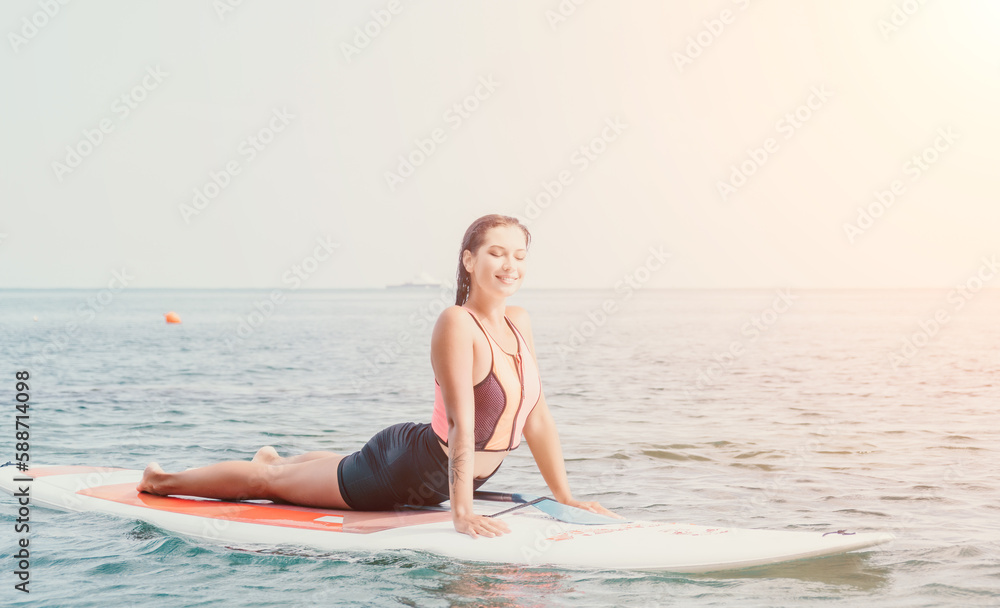 Woman sup yoga. Happy young sporty woman practising yoga pilates on paddle sup surfboard. Female stretching doing workout on sea water. Modern individual female outdoor summer sport activity.