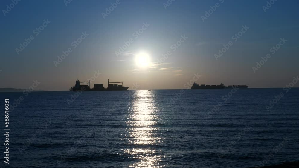 Silhouette of marine transport and tanker ships on open ocean water at sunset Silhouette of marine transport and tanker ships on open ocean water at sunset
