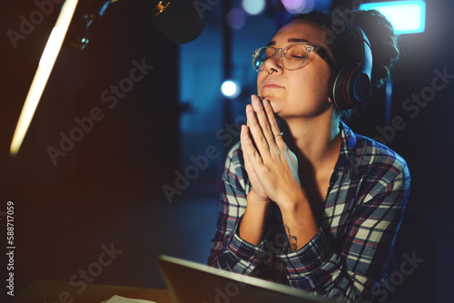 Radio dj, presenter pray and woman in a sound production studio taking praying break at work. Headphones, recording and thinking female employee ready for discussion on air for web podcast and music