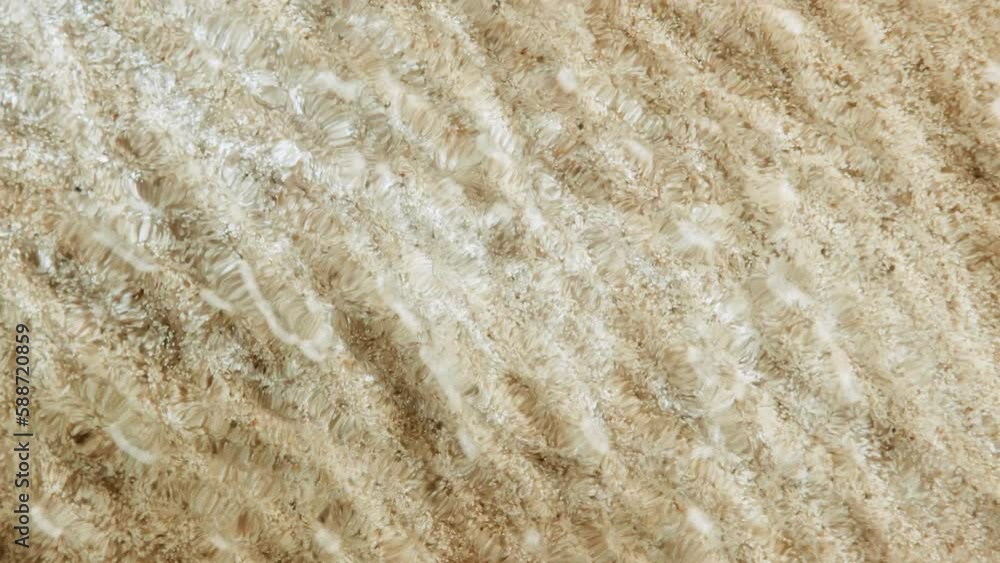 Top down view seabed texture, sea floor beach sand ripple of water waves reflection. Yellow sandy river bottom surface summer background slow motion. Underwater seafloor close-up Top down view seabed texture, sea floor beach sand ripple of water waves reflection. Yellow sandy river bottom surface summer background slow motion. Underwater seafloor close-up