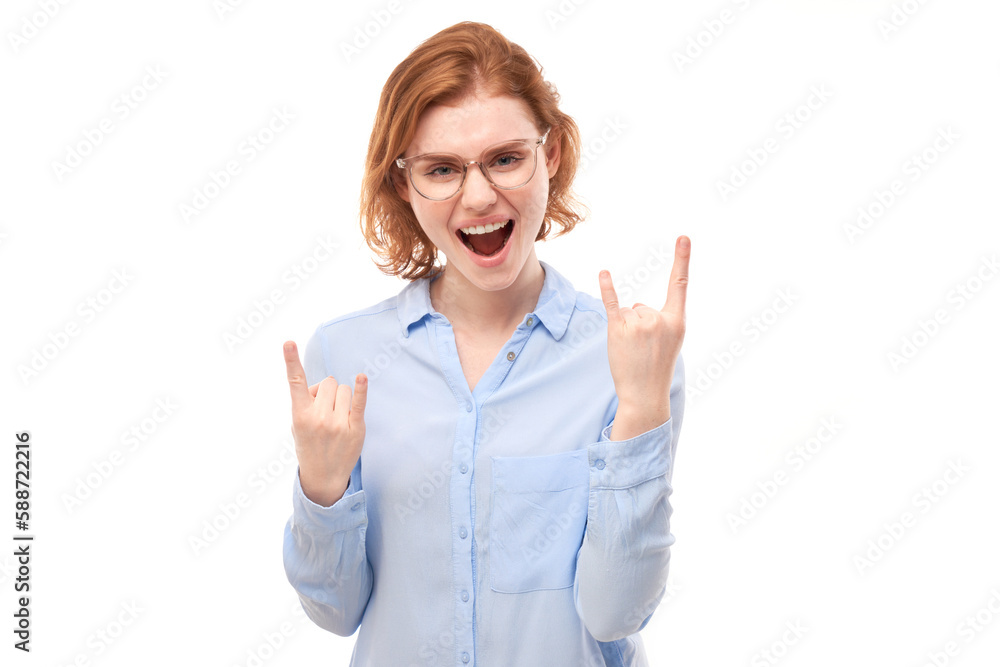Portrait of young redhead woman showing rock and roll gesture with fingers isolated on white background Portrait of young redhead woman showing rock and roll gesture with fingers isolated on white background