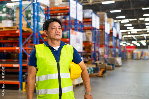 Portrait warehouse senior man worker wearing hard hat helmet and working at warehouse factory. Wholesale Merchandise. shelves, pallets and boxes
