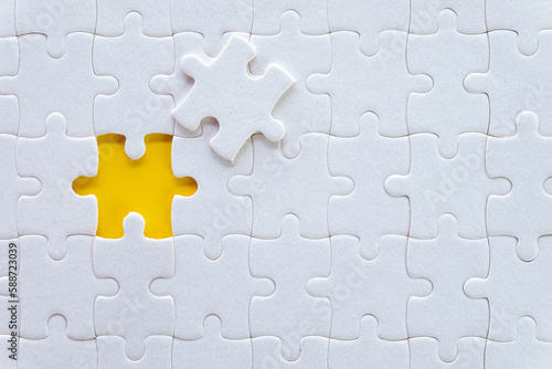 Top view of White jigsaw puzzle texture over yellow background.