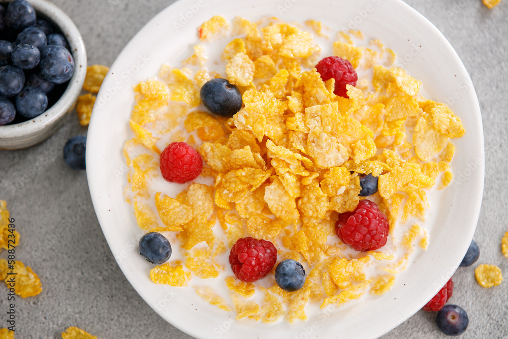Tasty corn flakes with blueberries and raspberries in a black bowl, top view Tasty corn flakes with blueberries and raspberries in a black bowl, top view