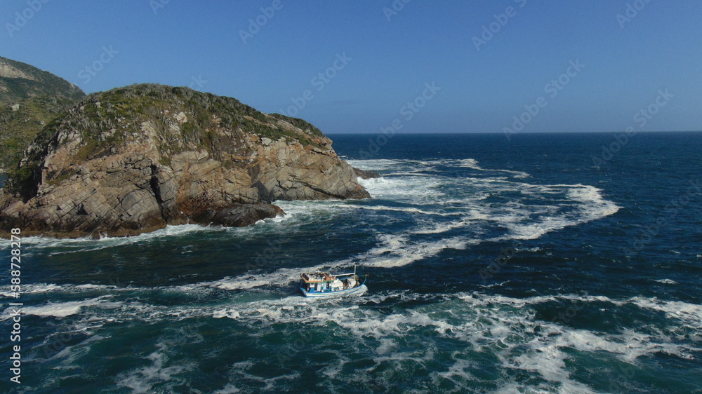 fishermen boat facing the strong sea in arraial do cabo brazil