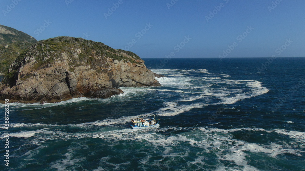 fishermen boat facing the strong sea in arraial do cabo brazil fishermen boat facing the strong sea in arraial do cabo brazil