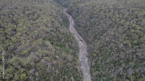 River Between Dense Trees In The Forest In Douglas-Apsley National Park, Tasmania, Australia. - aerial photo