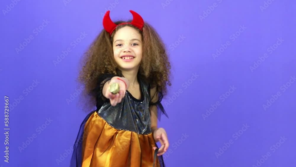A young girl on a purple background shows emotions, the concept of the holiday Halloween A young girl on a purple background shows emotions, the concept of the holiday Halloween