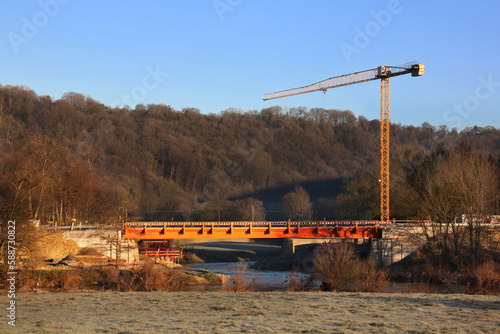 Crane on the construction site of a provisional bridge after Prüm river flood in Minden village, Eifel region in Germany