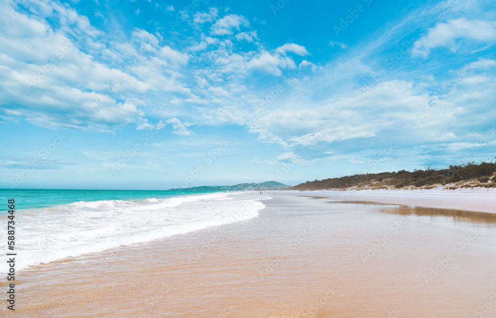 Stunning panoramic view of the ocean and beautiful waves rolling in on a pristine sandy beach. 