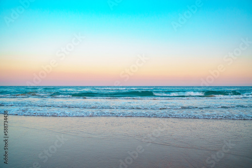 Mesmerizing sunrise over Pacific ocean and beautiful turquoise waves rolling in on a pristine sandy beach.  © SeaRain