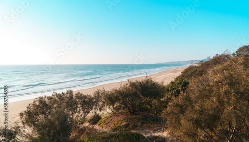 Amazing wide panorama of Peregian Beach on a sunny day. Spectacular beach background with blue turquoise water visible from the hill. Beautiful travel destination. Noosa, Sunshine Coast, Australia.
