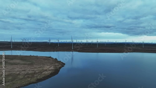 Wallpaper Mural Aerial rising shot showing wind turbines spinning in a large windfarm next to a lake Torontodigital.ca
