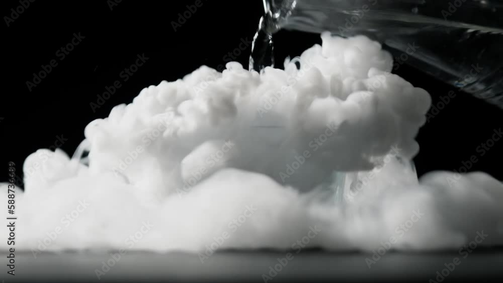 Dry ice creates a fog effect, pouring in hot water into glass with ice