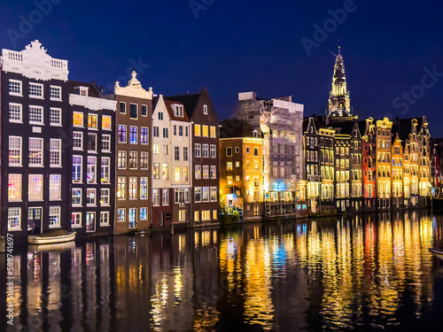 Damrak narrow houses at night in Amsterdam center, Netherlands