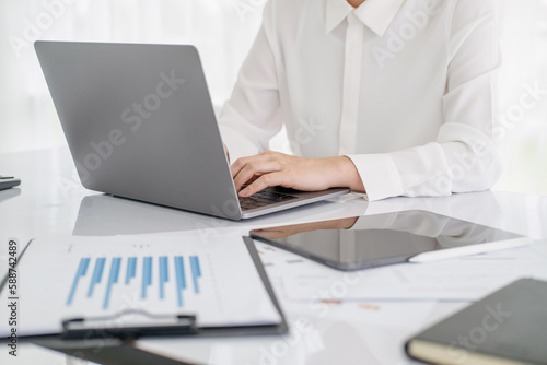 Closeup of hand asian businesswoman working on laptop computer on desk at office, freelance looking and typing on notebook, woman studying online, business and education concept.