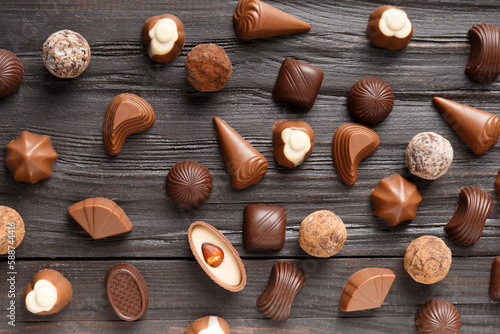 Assorted chocolates on dark wooden background top view