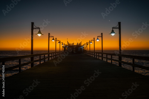 Fototapeta Naklejka Na Ścianę i Meble -  Beautiful Romantic Orange Sunset at Wooden Pier at the Sea
