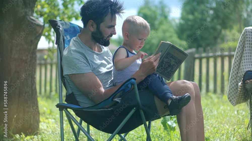 Kid with father reading book . Daddy reading fairy tale story Kid with father reading book . Daddy reading fairy tale story