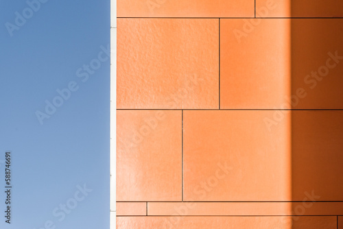 Kolorowy detal na elewacje obiektu, budynku. Materiał z pionowych aluminiowych i pomarańczowych paneli. Nowoczesny budynek