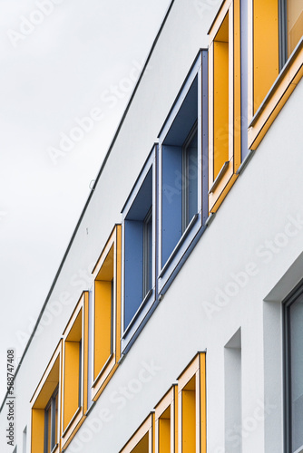 Kolorowa elewacja obiektu, budynku. Materiał z pionowych paneli. Obicia okien.