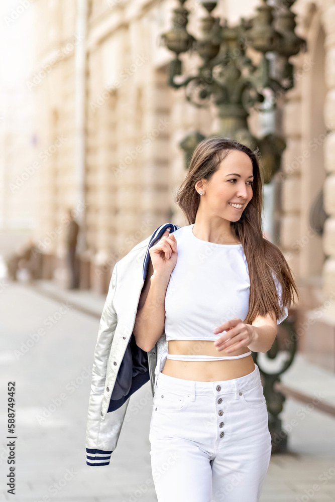 A happy cheerful girl is running and dancing on the street. A happy cheerful girl is running and dancing on the street.