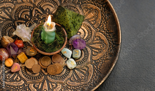 Witch altar. candle, different old coins, stone runes, crystals in plate on dark abstract background. Magic ritual for attracting money, wealth. witchcraft esoteric practice. top view