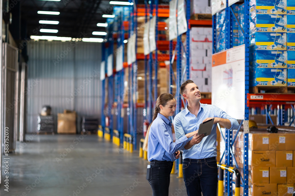 Caucasian team man and woman worker working at warehouse factory. Warehouse staff worker standing by goods shelf working in large warehouse Caucasian team man and woman worker working at warehouse factory. Warehouse staff worker standing by goods shelf working in large warehouse