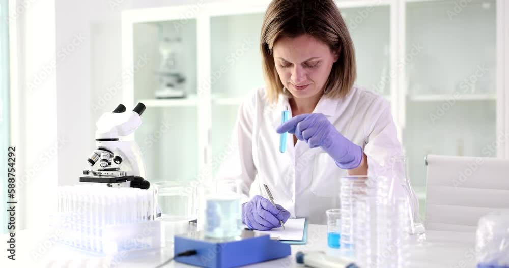 Chemist hand with records of observations in laboratory of toxic liquid. Study of poisonous chemical compounds Chemist hand with records of observations in laboratory of toxic liquid. Study of poisonous chemical compounds