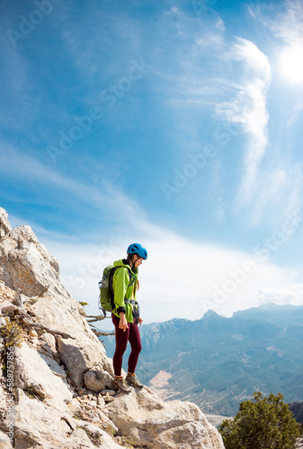 climber stands on top of the mountain. girl climber in a helmet and with a backpack mountains. Turkey.